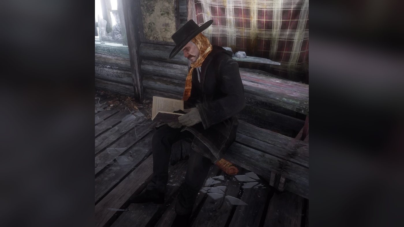 Swanson sitting on a bench in a cabin, reading