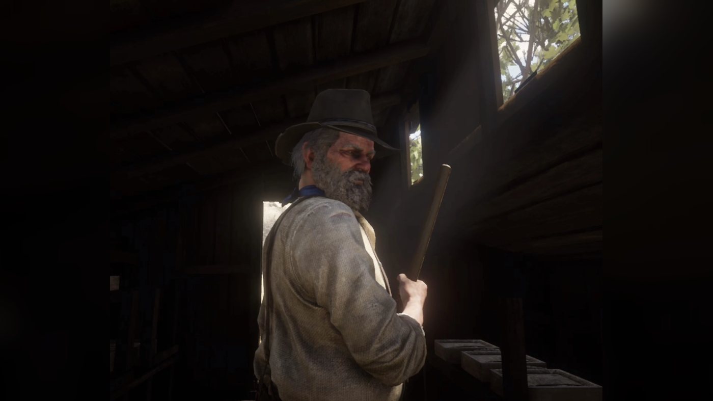 Uncle holding a broom inside a dark building